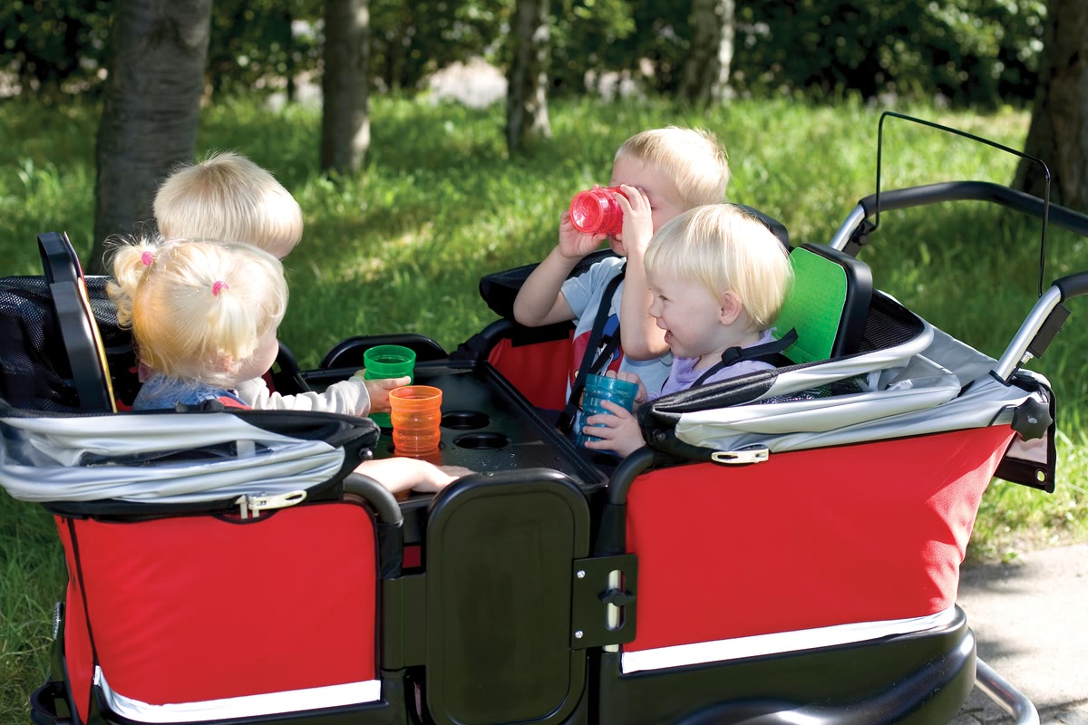Krippenkinder sitzen im Winther Turtle Kinderbus und machen eine Trinkpause
