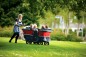 Preview: Erzieherin schiebt den Winther Turtle Kinderbus de Luxe mit Kindern über die Wiese
