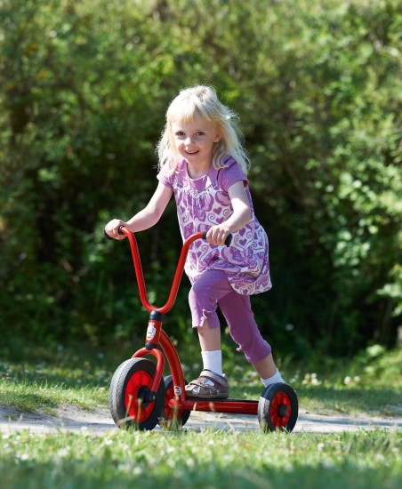 Preview: Mädchen fährt den Winther Mini Viking Dreirad Roller auf einer Wiese