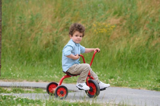 Preview: Kleinkind fährt das Winther Mini Viking Krippen Dreirad mit Steg, Seitenansicht