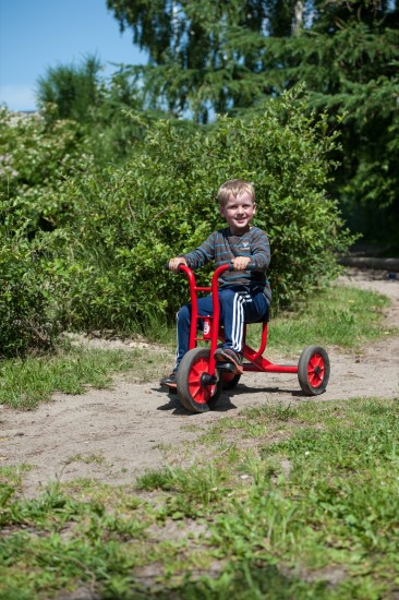 Preview: Kind fährt das Winther Viking Dreirad mittel auf einem Waldweg