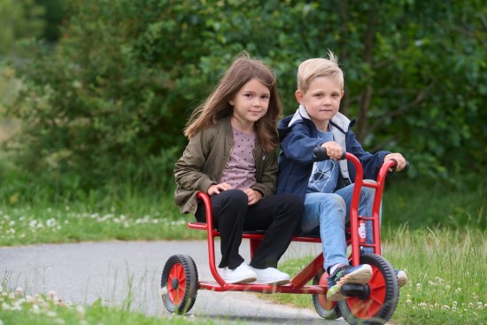 Preview: Mädchen und Junge sitzen nebeneinander auf dem Winther Viking Dreirad SideBySide Taxi