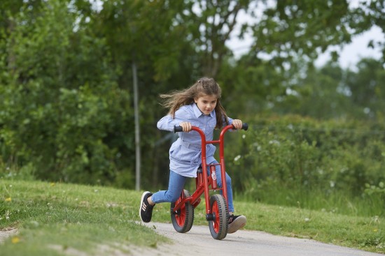 Preview: Mädchen fährt das Winther Viking Lernfahrrad auf einem Parkweg