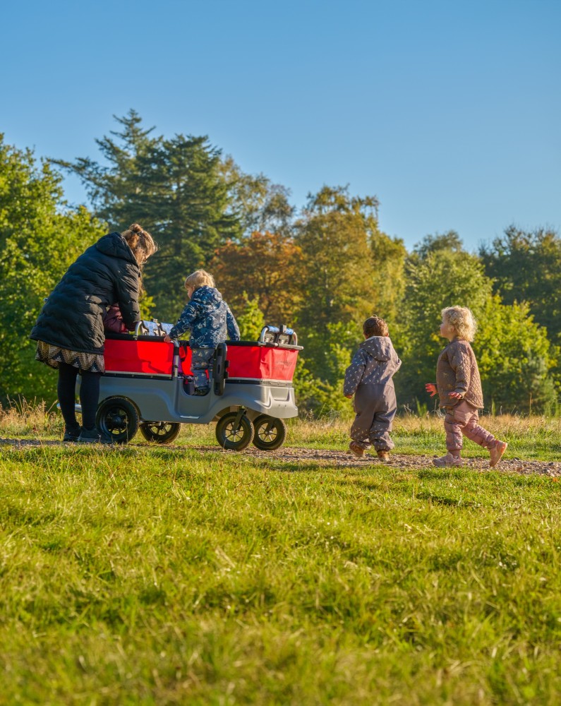 Kita-Gruppe mit dem Winther Turtle Kinderbus für 6 Kinder auf einer Wiese