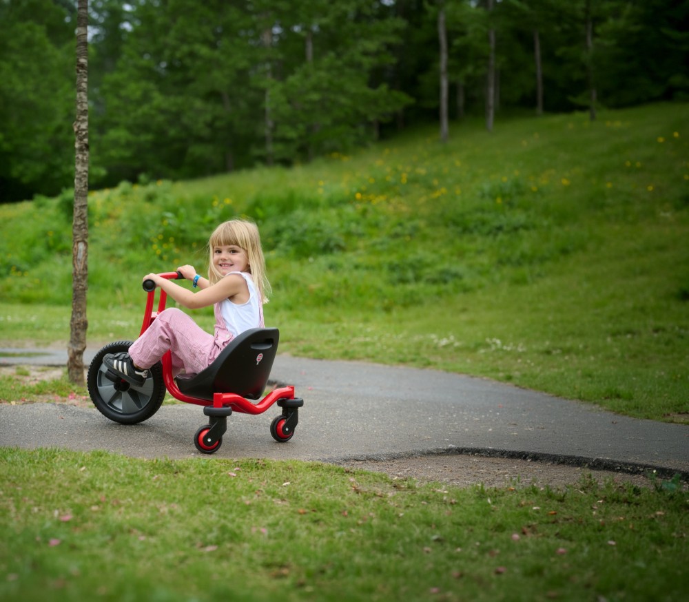 Mädchen fährt mit dem Winther Viking Challenge Swing Trike einen Weg entlang