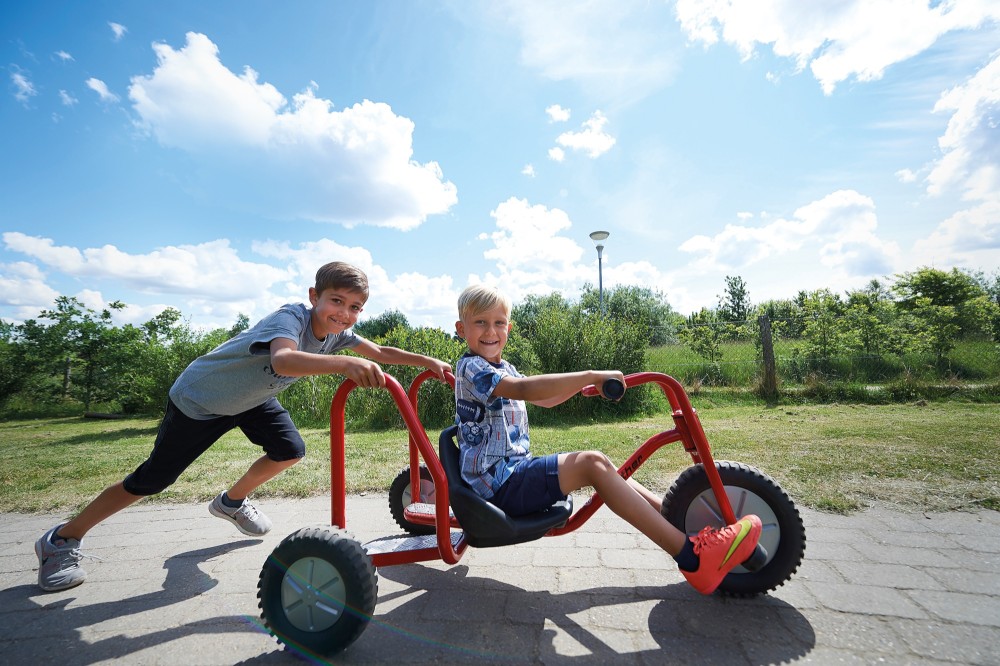 Junge schiebt den Winther Viking Explorer Bob Kart mit Fahrer über den Schulhof