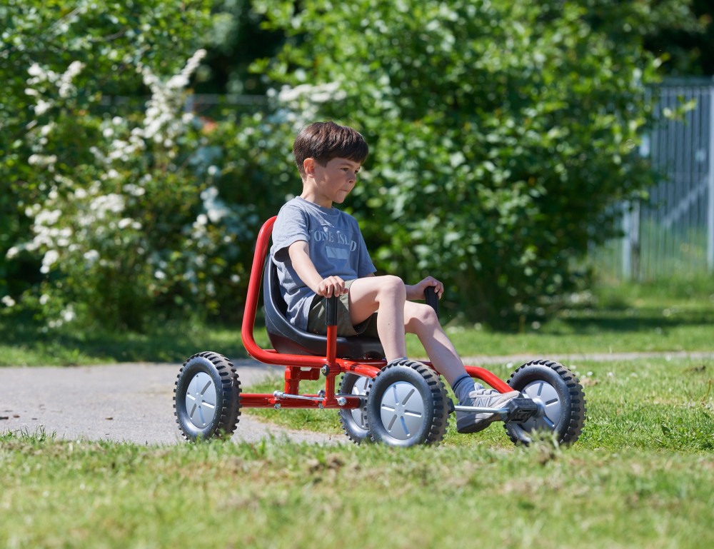Junge fährt den Winther Viking Explorer Fun Cart Large auf einem Parkweg, Seitenansicht