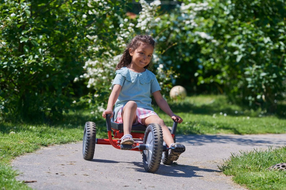 Mädchen fährt den Winther Viking Explorer FunRacer auf einem Parkweg