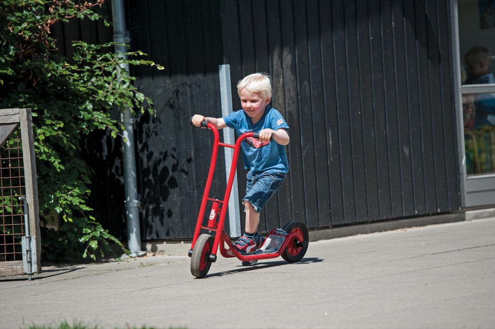 Junge fährt den Winther Viking Roller klein auf dem Kita-Hof